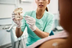 Dentist explaining the dental implant process to a patient during a consultation